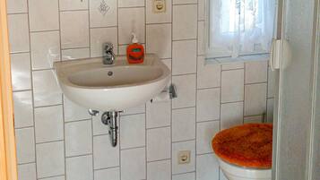 Ein Badezimmer mit Waschbecken, Toilette und Fliesen.