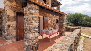 A stone building with a tiled patio and a table set for dining. - Holiday apartment mit Terrasse (Pittulongu)