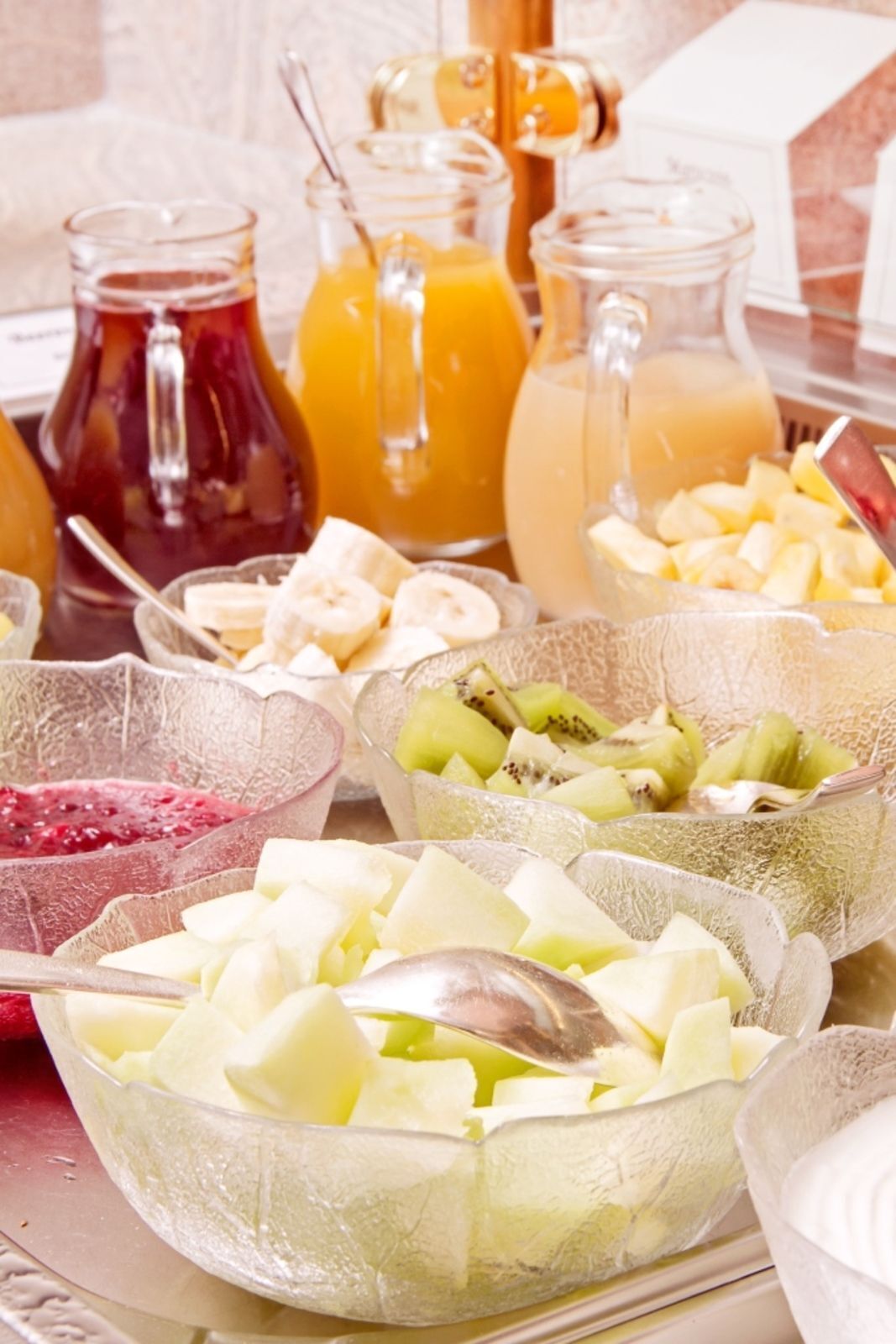 A breakfast buffet with various fruits and beverages.