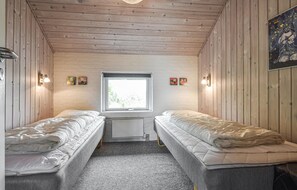 Two single beds are aligned in this compact room, separated by a window with a view.