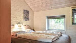Una camera da letto con un letto, una finestra, una lampada a parete e un quadro.