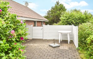 Relax in a serene patio area with a brick-paved path leading to a table and chairs.