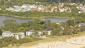 Un pueblo costero con playa, casas y un lago.