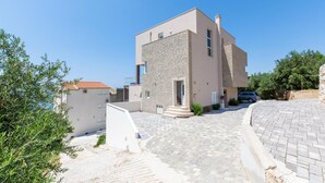 Un bâtiment moderne à deux étages, doté d’une façade en pierre et d’un toit plat.