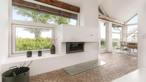 Eine moderne Küche mit großem Fenster, einem eingebauten Ofen und einem Boden aus Ziegelsteinen.