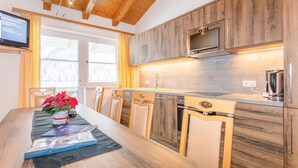 A modern kitchen with wooden cabinets, a built-in oven, and a large window.