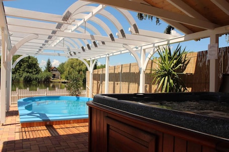 Outdoor spa tub. Holiday home right on the river with pool and hot tub