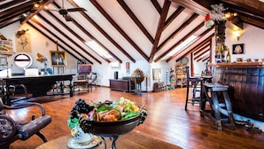 Un loft spacieux avec des poutres apparentes, un coin bar et une variété d’antiquités et d’objets de collection.