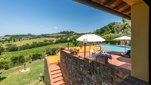 Une terrasse avec une piscine, des marches en pierre et des plantes en pot.