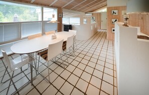 A modern kitchen with a white table, metal chairs, and a tiled floor. - 3 bedroom awesome home in Asperup (Asperup)