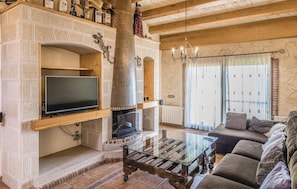 Cozy living room with a fireplace, flat-screen TV, and comfortable sofa.