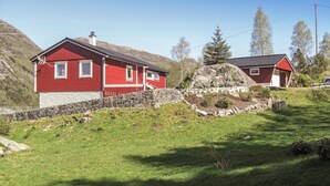 Una casa roja con pared y base de piedra.