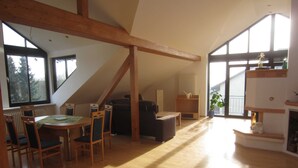 A spacious loft with high ceilings, large windows, and a wooden floor. - Küpfer vacation apartment (Gräfenberg)