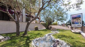 A courtyard with a small water feature, a staircase, and a building with a balcony. - Holiday apartment with one bedroom and balcony with sea view (Fažana)