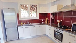A modern kitchen with white cabinets, a stainless steel refrigerator, a double sink, and a microwave. - Stunning home in Eyliac (Eyliac)