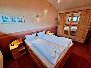 Ein Hotelzimmer mit einem großen Bett, einem Holzschrank und einem Gemälde an der Wand.