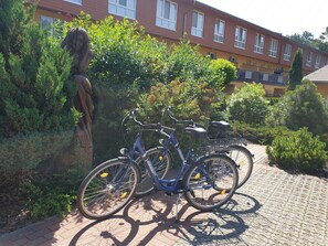 Una bicicleta estacionada en un área pavimentada, con un edificio al fondo.