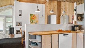 A modern kitchen with wooden cabinets, a built-in dishwasher, and pendant lighting. - Amazing home in Blåvand with sauna (Blåvand)