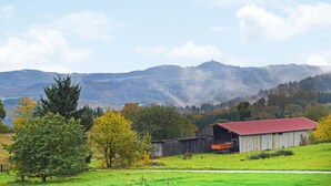A rural landscape with a barn, a tractor, and a clear view of distant mountains. - Beautiful apartment in Reifferscheid (Reifferscheid)
