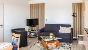 A compact living space with a sofa, a small table, a television, and a cabinet. - Beautiful apartment in Reifferscheid (Reifferscheid)