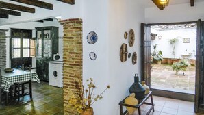 Um quarto aconchegante com uma mesa xadrez, uma máquina de lavar, um pilar de tijolos e uma porta que dá para um pátio com plantas.