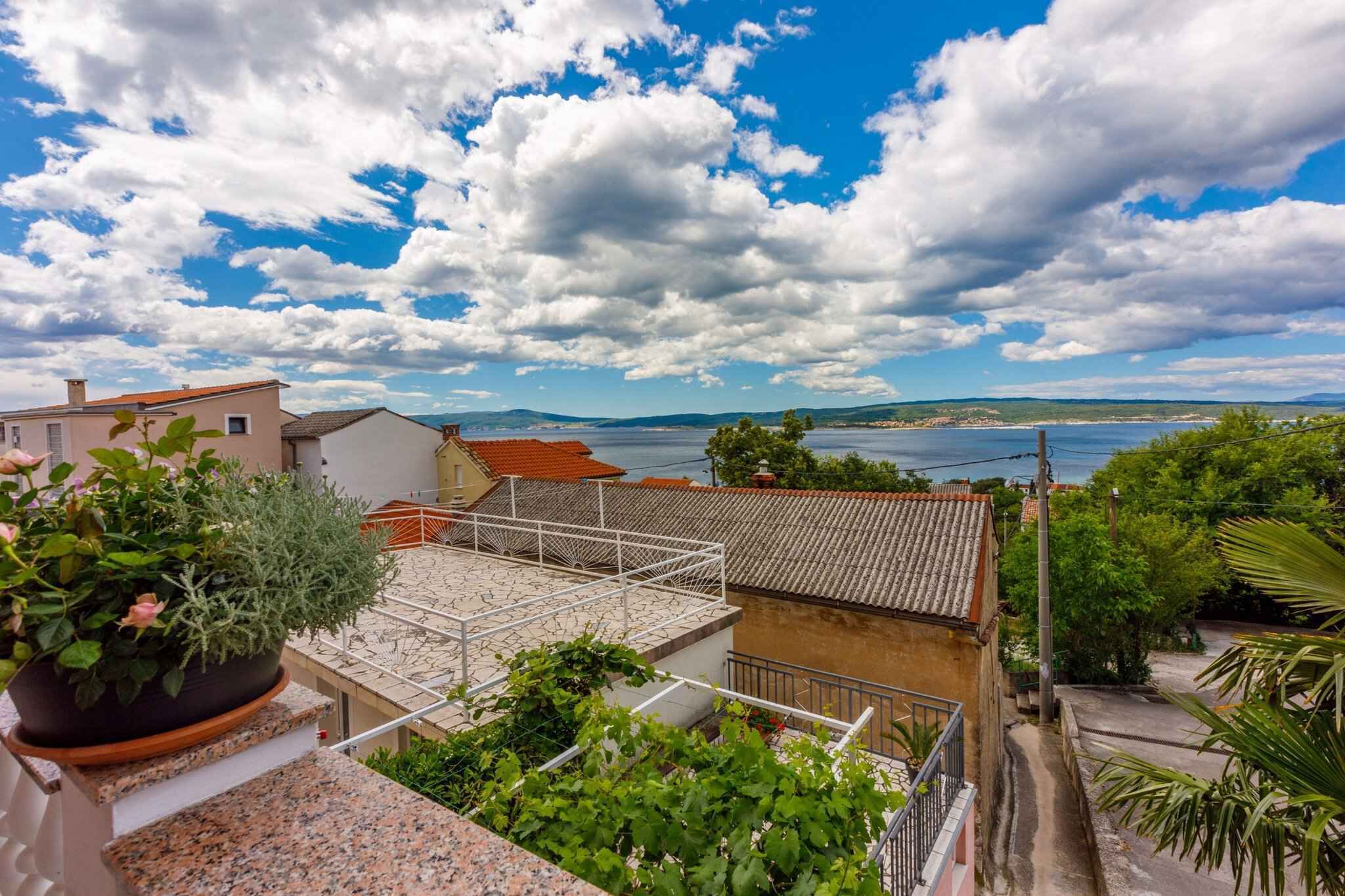 Zona residencial con vista al mar, techo de tejas y una planta en maceta.