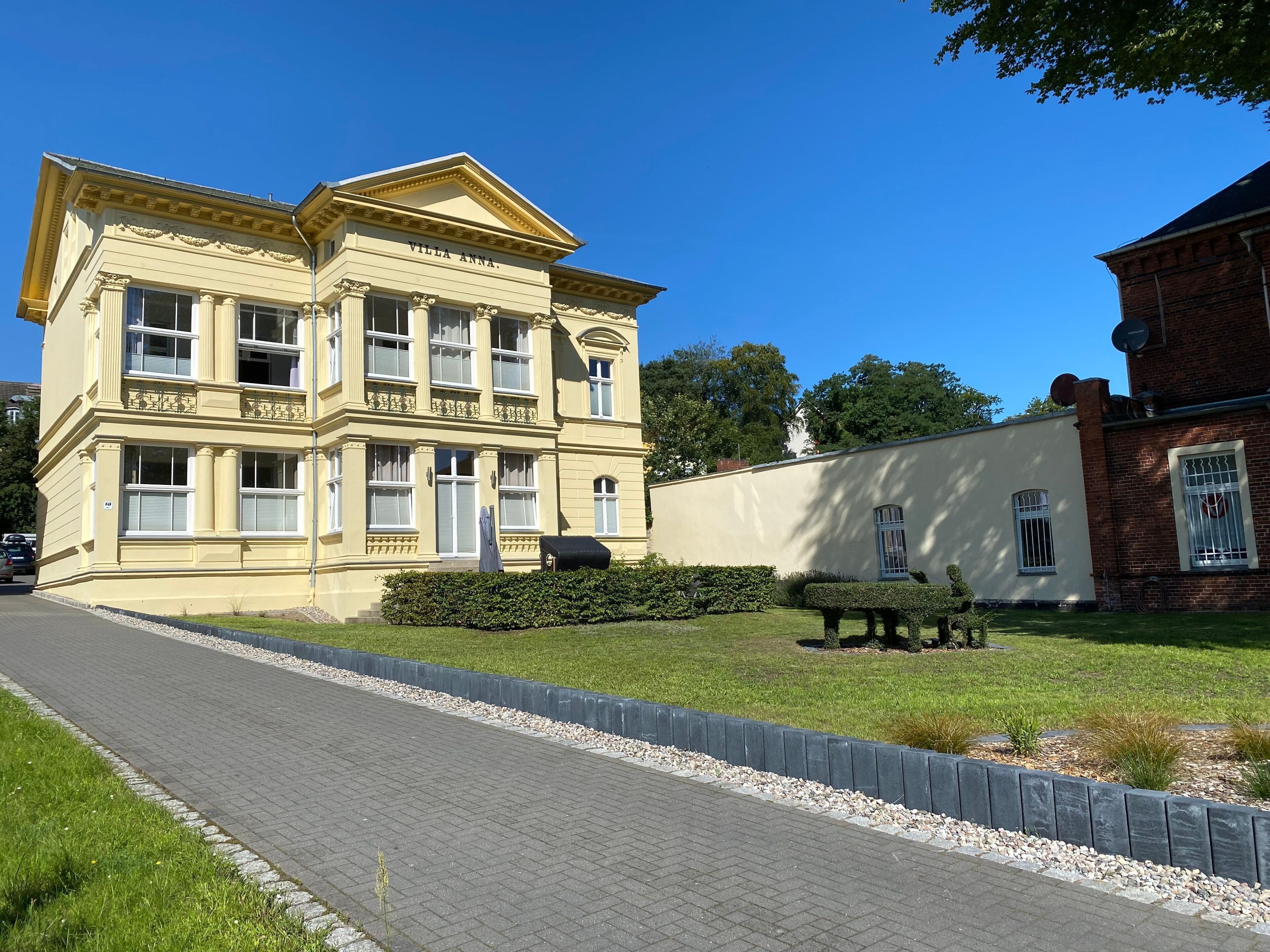 A large, classical building with a prominent entrance and a nameplate.