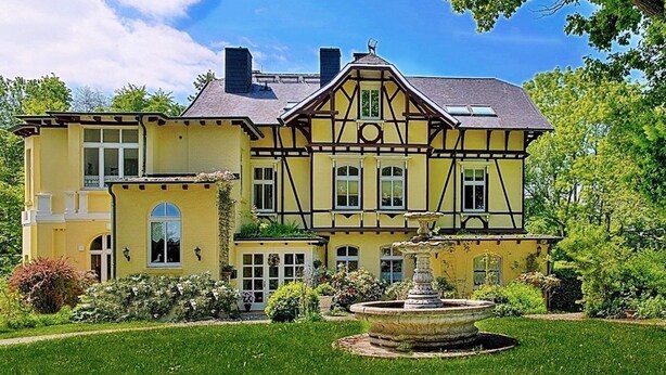 A two-story house with a garden and a fountain. - 2-room apartment no. 6, 35m², DG, West - Waldhaus Gronenberg (Scharbeutz)