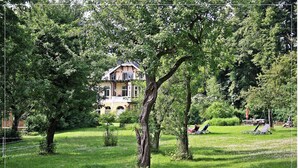 A large house surrounded by trees in a grassy area. - 2-room apartment no. 6, 35m², DG, West - Waldhaus Gronenberg (Scharbeutz)