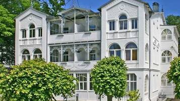 Ein mehrstöckiges, weißes Gebäude mit Balkonen und Rundbogenfenstern.