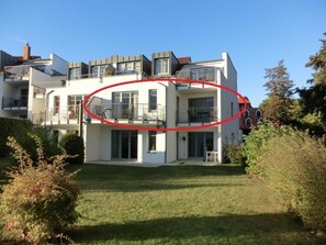 Une maison moderne à deux étages, dotée d’un balcon, d’une pelouse bien entretenue et surplombant un ciel dégagé.