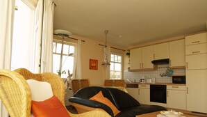 A living room with wicker furniture and a dining area with a table. - Amber Whg. BE-10 .. - Amber Whg. 10 (Kühlungsborn)