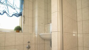 Un baño con inodoro, lavabo y zona de ducha.