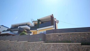 Una casa moderna de dos pisos con fachada de piedra y techo plano.
