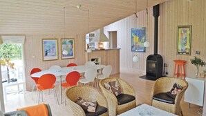 A spacious living area with a high ceiling, wooden walls, a fireplace, and modern furniture. - Awesome home in Væggerløse with sauna (Væggerløse)