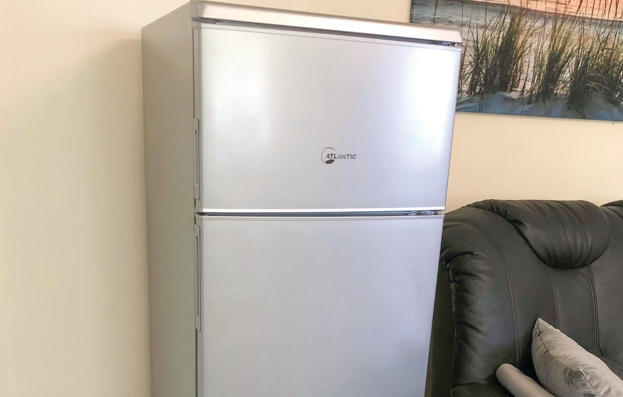 Un refrigerador plateado con la marca 'ATLANTIC' en la parte superior.