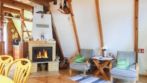 A cozy living room with a fireplace, wooden furniture, and a staircase leading to an upper level. - 2 bedroom stunning home in Mragowo (Mragowo)