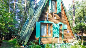 A wooden cabin with a sloped roof, green shutters, and a small porch area. - 2 bedroom stunning home in Mragowo (Mragowo)