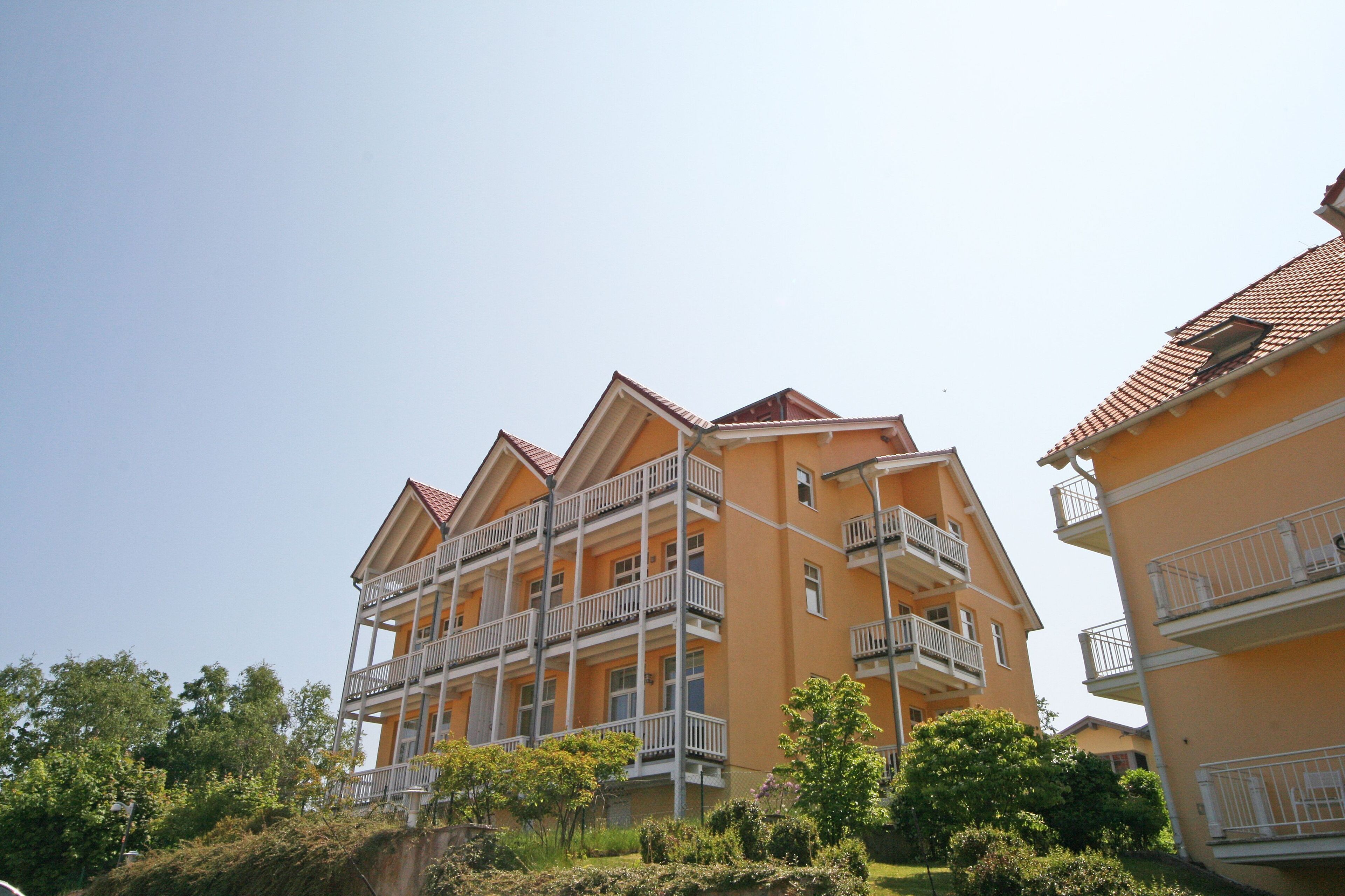 A multi-story building with balconies and a clear sky.