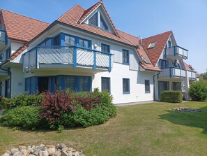 A two-story house with a balcony, a red-tiled roof, and a well-maintained lawn. - Oewern Diek 23, Germany (Wustrow)