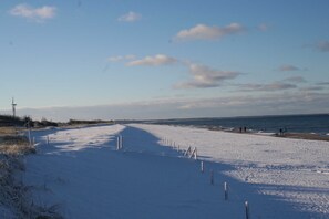 A snow-covered beach with a clear sky and a few clouds. - Oewern Diek 23, Germany (Wustrow)