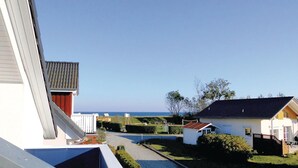 Quartiere residenziale con case, cielo sereno e vista sul mare.