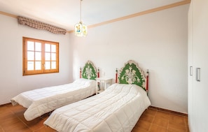 A room with two single beds, a window, a small desk, and a decorative headboard. - Mas Girones: Rural con piscina (Riudellots)