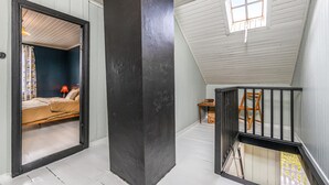 Une pièce avec un lit, une fenêtre et un escalier.