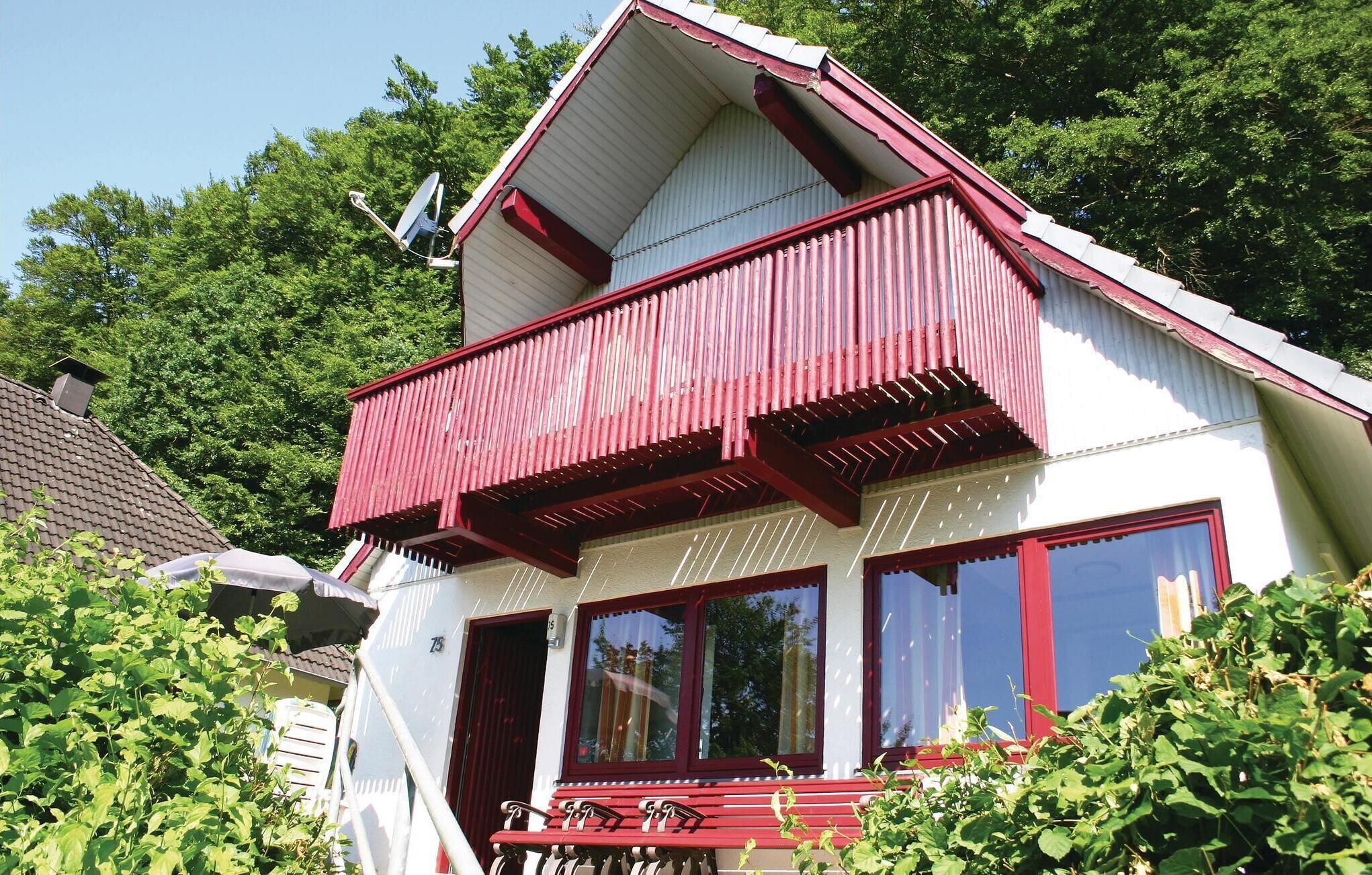 Une maison à deux étages avec un balcon rouge et une antenne parabolique.