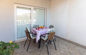 A patio with a table set for two, featuring wicker chairs and a tablecloth. - 2 bedroom cozy apartment in Klek (Klek)
