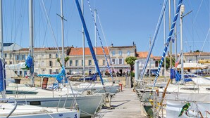A marina with boats docked in front of a row of buildings with red-tiled roofs. - Stunning home in Cézac (Cézac)