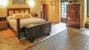 A bedroom with a wooden bed, a nightstand, a dresser, and a patterned rug. - Stunning home in Cézac (Cézac)