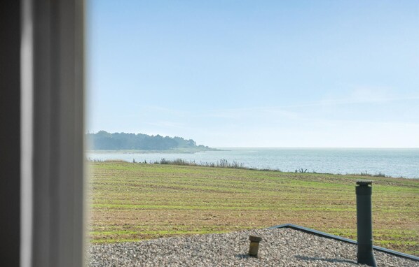 A view of a grassy area with a body of water and a distant tree line. - Stunning home in Sydals with sauna (Sydals)
