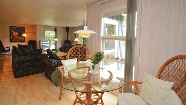 A cozy living room with a glass-top coffee table, wicker chairs, and a sofa. - 5 bedroom amazing home in Væggerløse (Væggerløse)